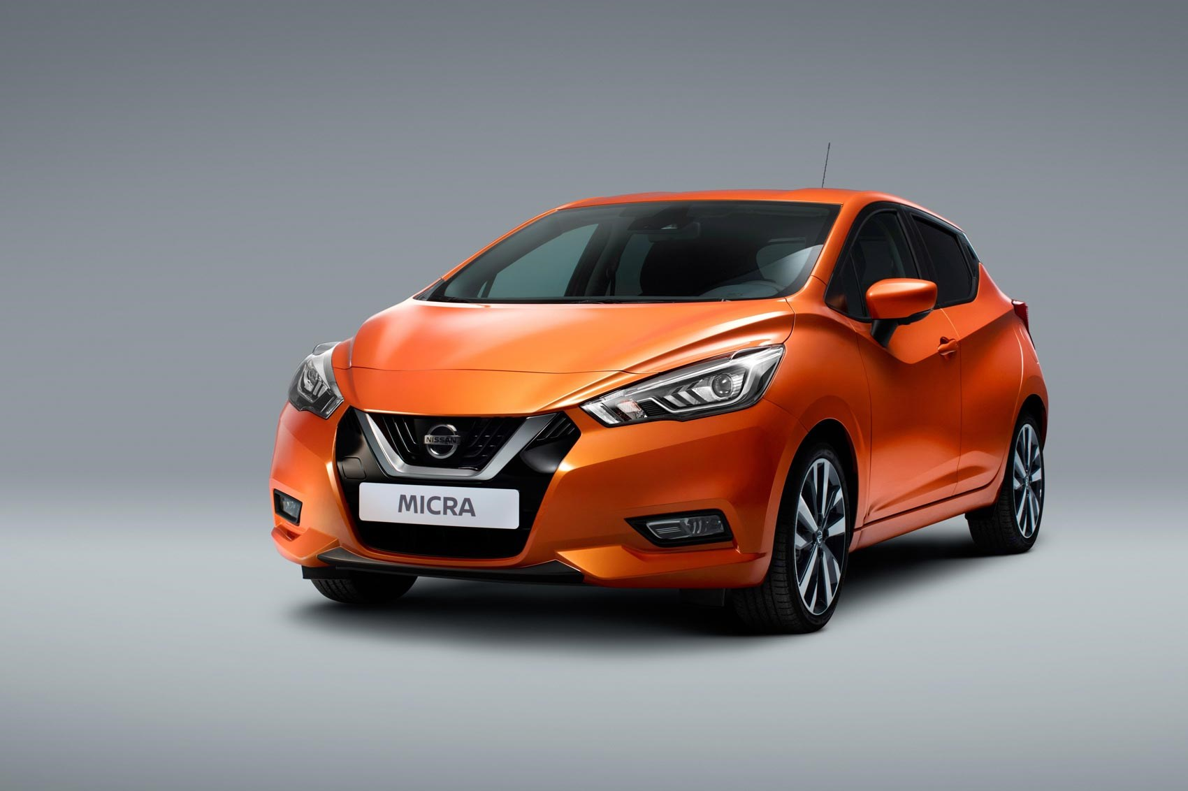 Orange Nissan Micra on a grey background