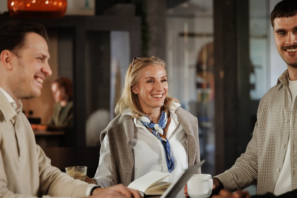 A smiling woman in a conversation next to her coworkers