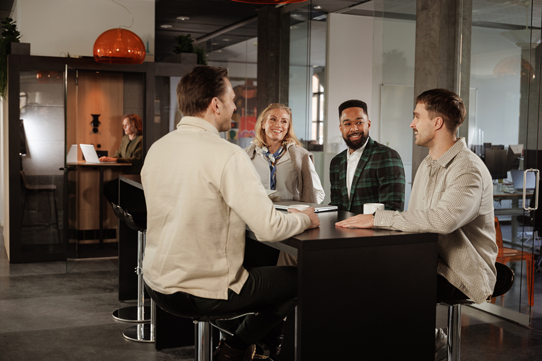Coworkers in a conversation at a high table in their office